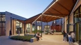 Renovated entry court with weather canopy provides exterior gathering spaces
