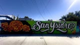 mural depicting flowers and san ysidro in cursive writing