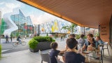 family sitting at an outdoor table across the street from strong museum of play