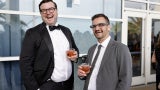 two men in suits holding red beverages AIA26 opening night party hilton bayfront