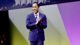 man in blue suit against stage background san diego mayor todd gloria