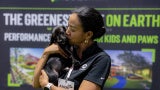 woman kissing a black lab puppy on expo floor