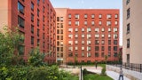 rendering of a red brick development with a walkway and green space