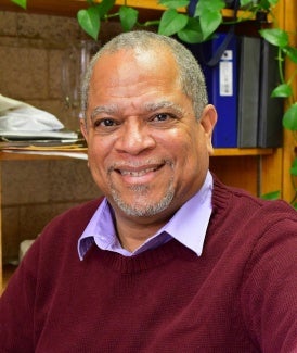 Headshot of a man wearing a collared shirt and sweater