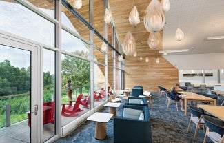 Library interior; couches look out toward large windows and view of the porch and outdoors