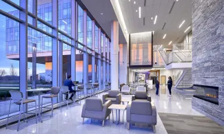 Interior lobby of Allegheny Health Network Wexford Hospital at sunset with people talking
