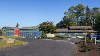 Residential community exterior at day; view from driveway to the buildings