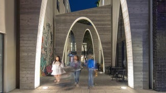 View from inside of Jade Alley at night, with people walking through.