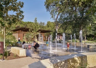 Children playing in fountain of Kingsbury Commons at Pease Park 