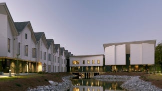 Outdoor view of houses and attached buildings surrounding a body of water.