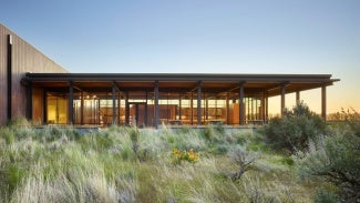 modern one story building in a field at sunset