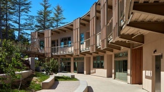 Flexible outdoor learning spaces along the west elevation engage the hillside.