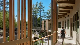 Exterior circulation along the west elevation connects the classrooms while providing framed views to the forest beyond.