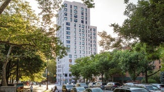 Greenery surround the high-rise facility.