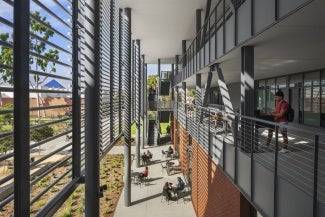 Perpendicular view of an external screen and balcony at an educational building.