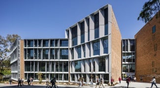 External view of an educational building with large glass windows at day.