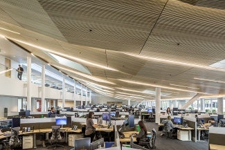 A large open office with wooden ceiling panels.