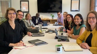 A group of people sitting at a long boardroom table. 