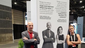 Two people standing in front of a display on an Expo floor