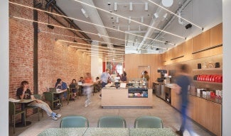 Coffee shop interior with exposed brick wall and light wood cabinetry