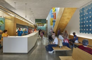 Interior of a community building with a large white front desk and colorful wayfinding. 