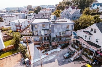 Rear elevation of a residential building at day with view from the alley.