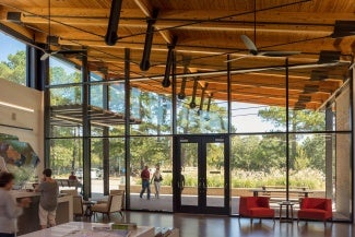 Interior lobby space with view to the outdoors through glass curtain wall. 