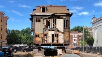 Rear elevation of a historic building sitting up on the lifts. The rear facade is missing. 