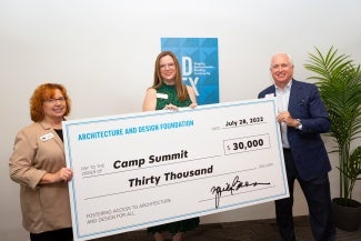 A man and two women hold and giant novelty check