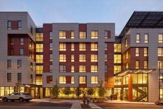 Distinct entries to two different buildings on either side of shared entry court. 