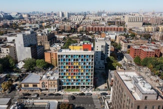 Gridded concrete façade with colorful painted steel panels stands out in