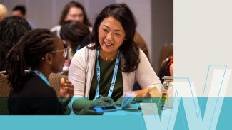 Diverse women interacting and learning at Women's Leadership Summit. 