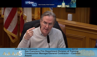 man in gray collared shirt speaking at public works commission hearing