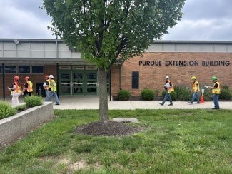 workers wearing personal protective gear and walking in the same direction
