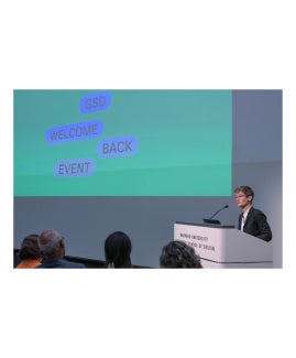 Sarah W. standing at a podium giving a presentation