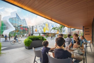 family sitting at an outdoor table across the street from strong museum of play