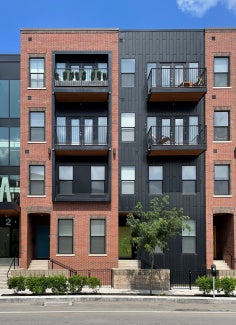 four story brick and black residential building in the neighborhood of play
