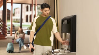 A person using a water fountain in a school