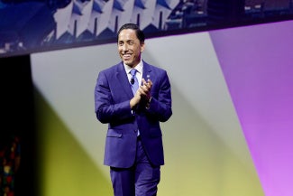 man in blue suit against stage background san diego mayor todd gloria