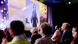 A crowd listens to a talk