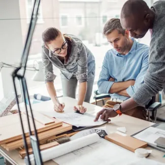 two males and one female collaborating at a desk