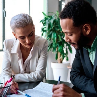 two individuals in suits reviewing a contract