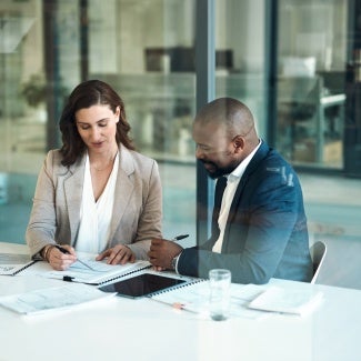 two individuals looking at a document