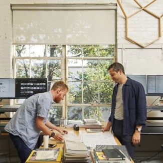 Two people looking at papers on a desk