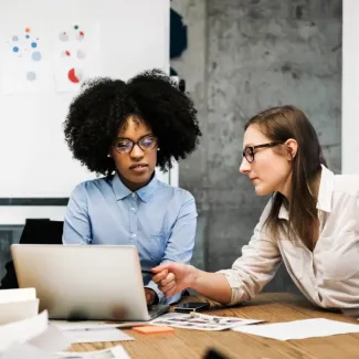 two woman looking at a laptop