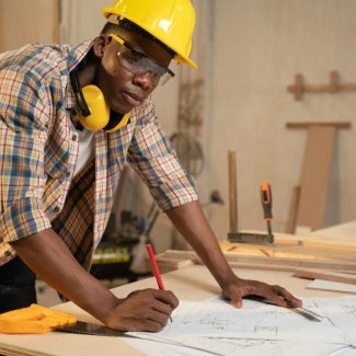 Person with construction helmet and plans