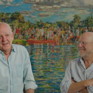 Two men in button down shirts are talking in front of a watercolor painting.