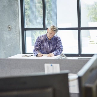 Architect thoughtfully working at draft table