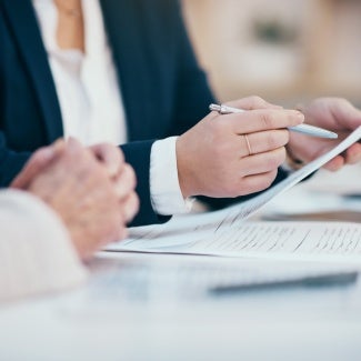 Hands closeup on contact, legal settlement or financial report while reading and making notes. Lawyer team doing work and analyzing documents. Lawyers looking through client finance data together