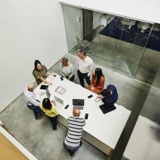 Businesswoman leading project meeting at conference table in office.